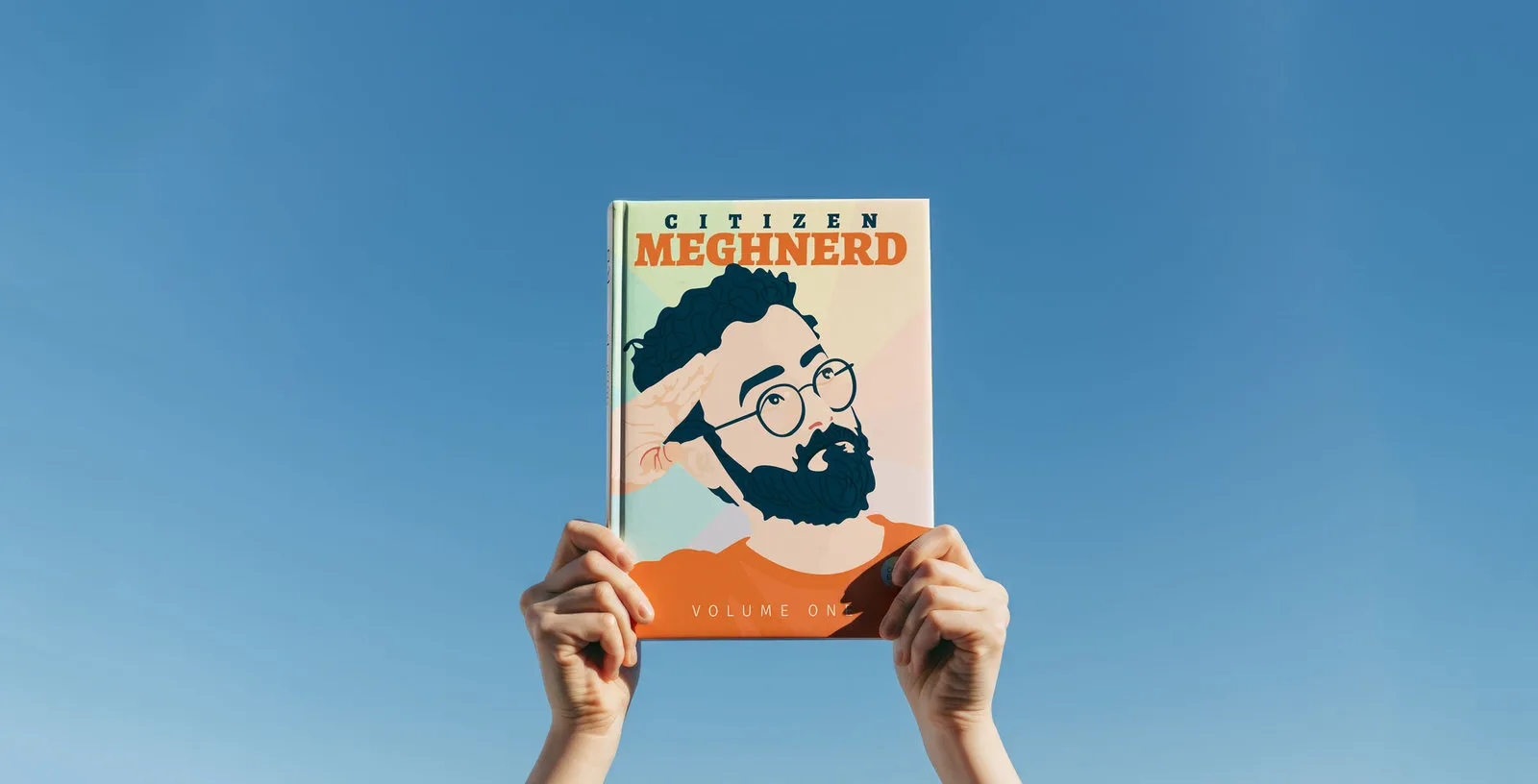 A Citizen Meghnerd journal held up against a blue sky